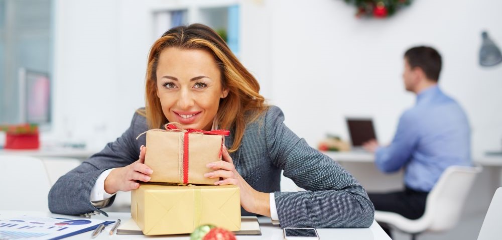 Mitarbeiterin mit Geschenk, Freude über Mitarbeitergeschenk