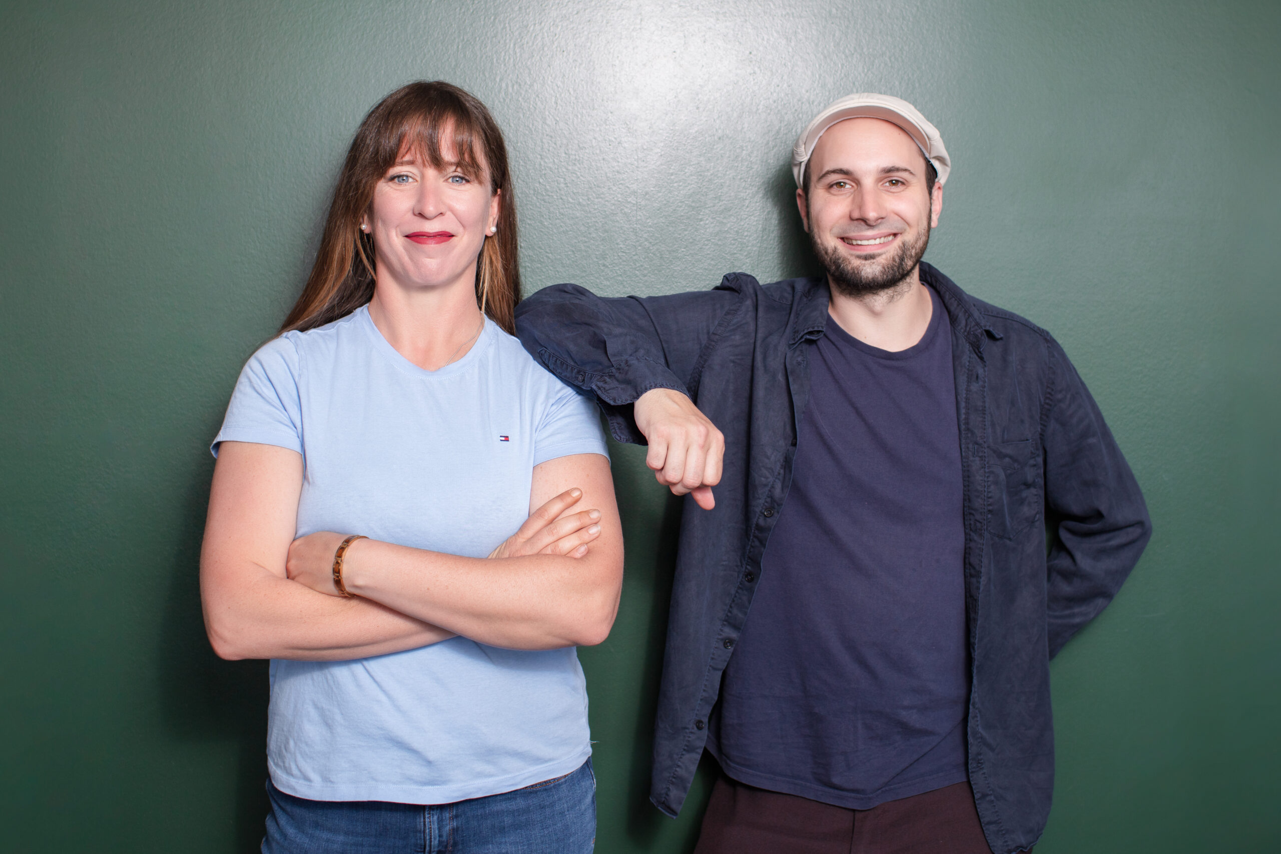 Bild von Nina Kirsch und Malchus Kern, der Gründerin und dem Gesellschafter von kirschwerk GmbH, vor einem grünen Hintergrund. Beide lächeln freundlich und stehen lässig nebeneinander.