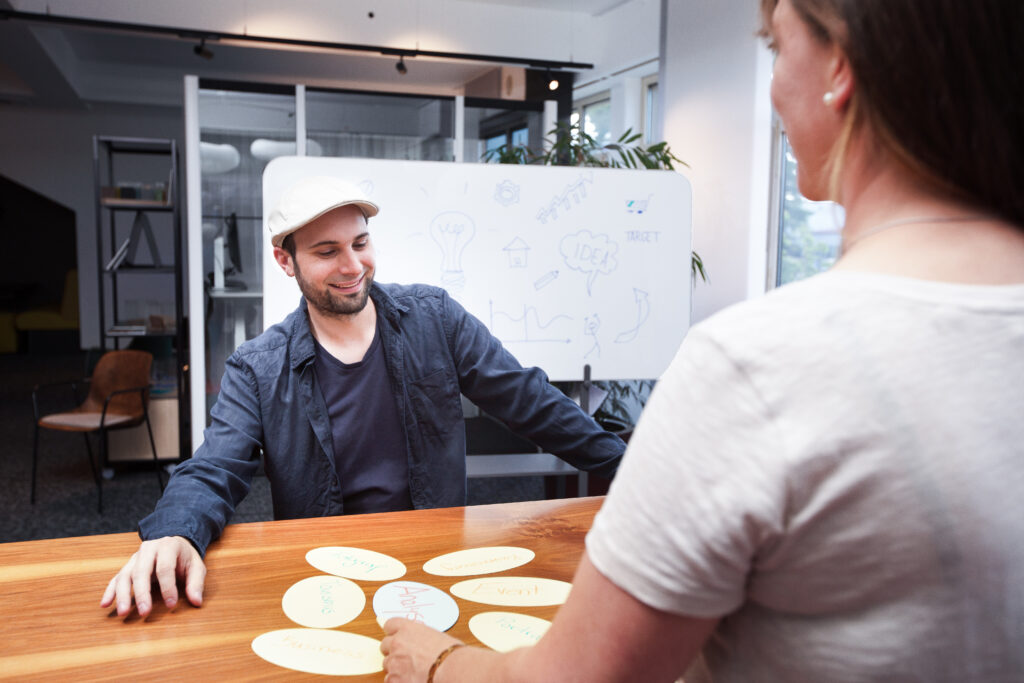 Bild von Nina Kirsch und Malchus Kern, die am Tisch sitzen und Brainstorming betreiben.