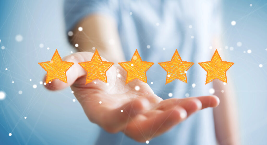 Bild einer ausgestreckten Hand, die fünf goldene, gemalte Sterne hält.