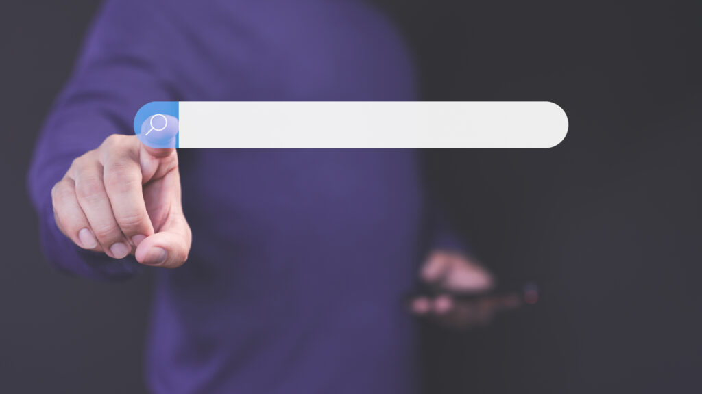 Bild eines Mannes, der in einer Hand ein Smartphone hält und mit der anderen ein Suchleisten-Symbol antippt.